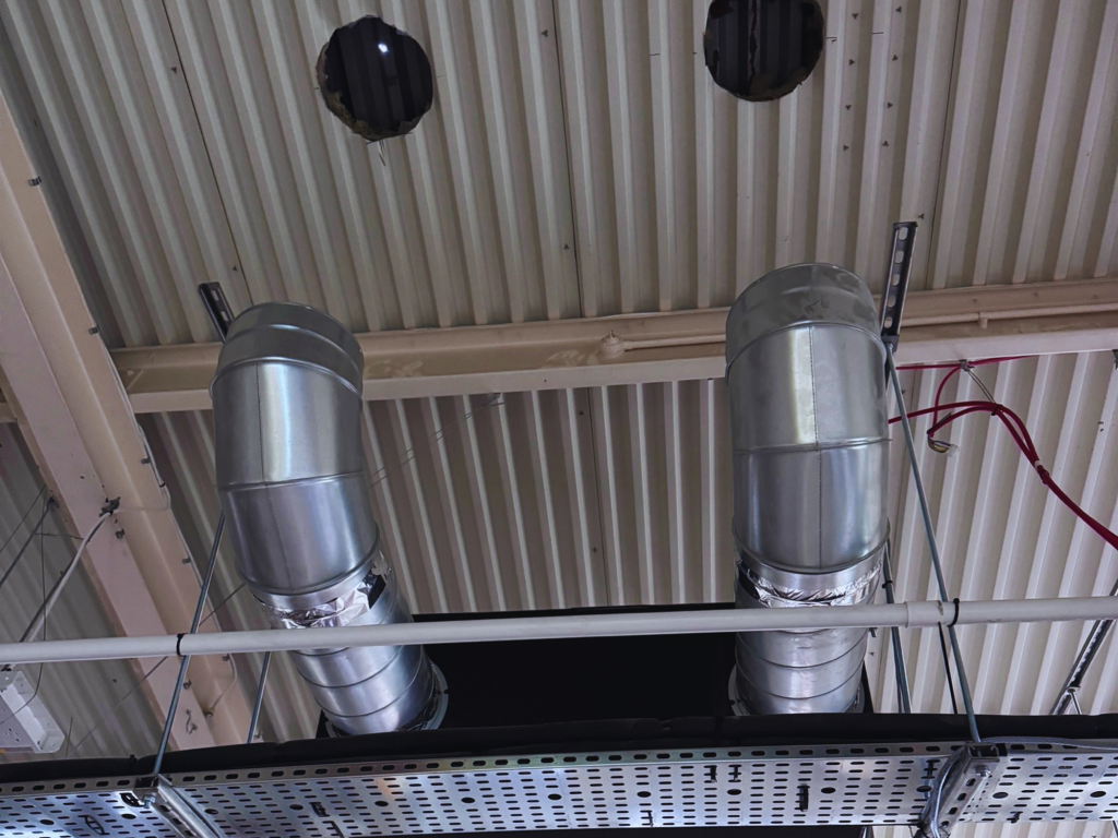 Commercial ventilation ductwork installed through an industrial ceiling